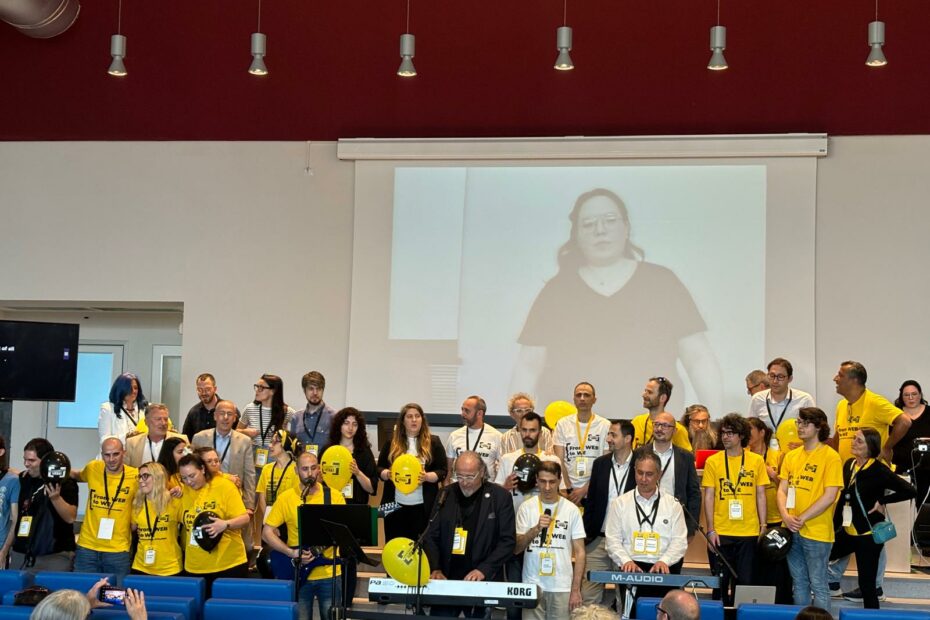 Organizzatori e relatori degli Accessibility Days 2024 cantano "We are the world" durante la chiusura dell'evento